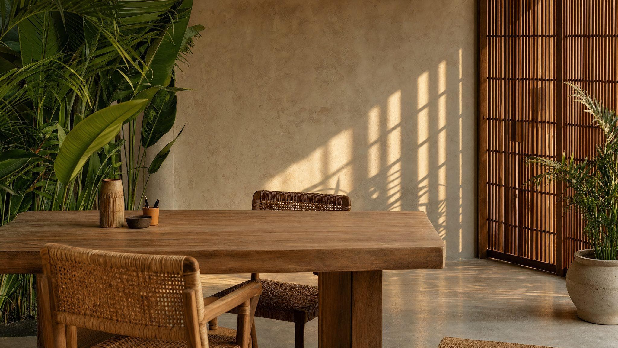 A warm Bali studio with a long wooden table in late light
